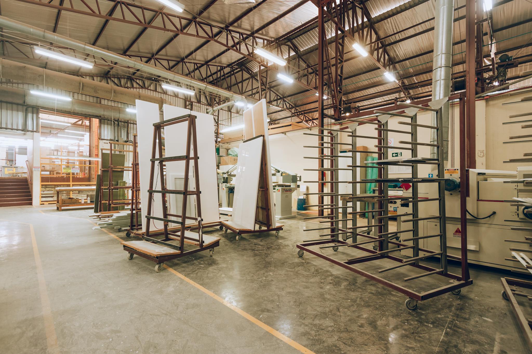 A large, well-lit industrial factory interior showcasing machinery and storage solutions.